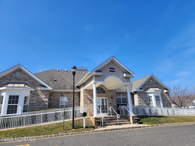 view of front facade featuring brick siding and a fenced front yard