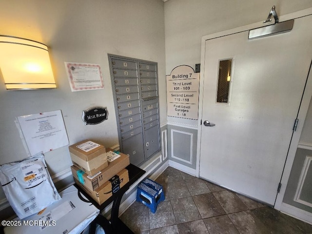 interior space with dark tile patterned floors and mail area