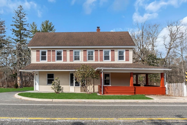 view of front facade featuring a chimney, a front lawn, roof with shingles, and fence