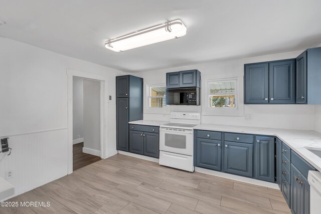 kitchen with blue cabinetry, white appliances, wood tiled floor, and light stone countertops