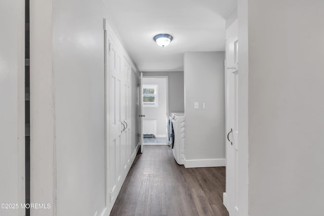 corridor with baseboards, independent washer and dryer, and dark wood finished floors