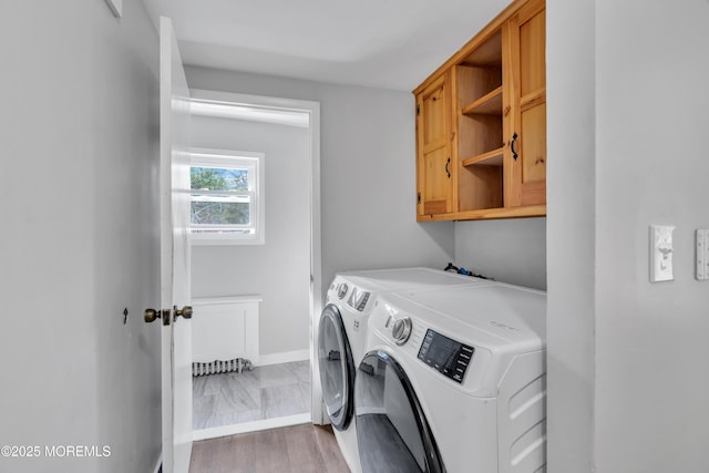 laundry area with baseboards, cabinet space, and separate washer and dryer