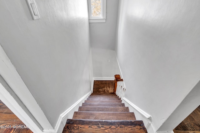 stairway featuring baseboards and wood finished floors