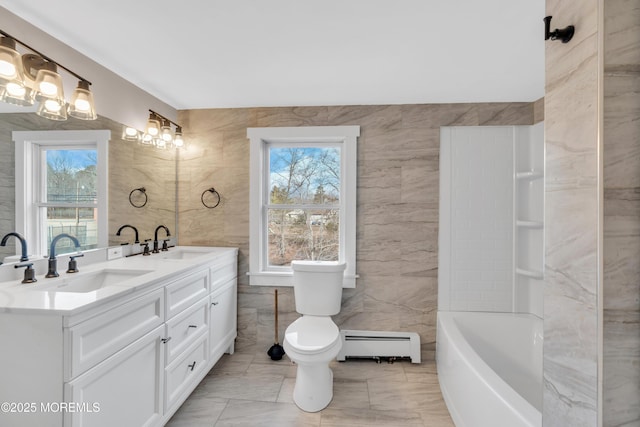 full bath with a sink, plenty of natural light, tile walls, and a baseboard radiator