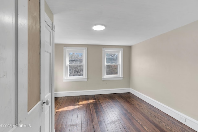 empty room with baseboards and dark wood-style flooring