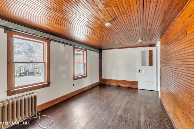 unfurnished room featuring wooden ceiling, radiator heating unit, baseboards, and wood finished floors