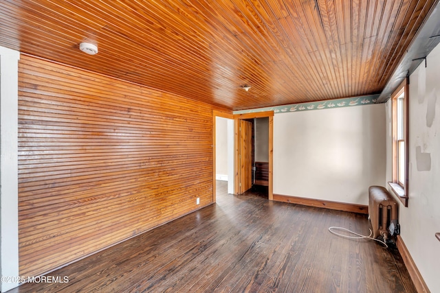 empty room with dark wood finished floors, wood ceiling, radiator heating unit, and baseboards