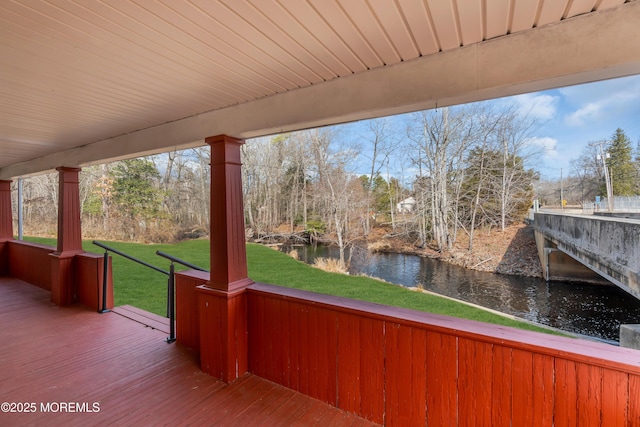 wooden deck featuring a yard and a water view