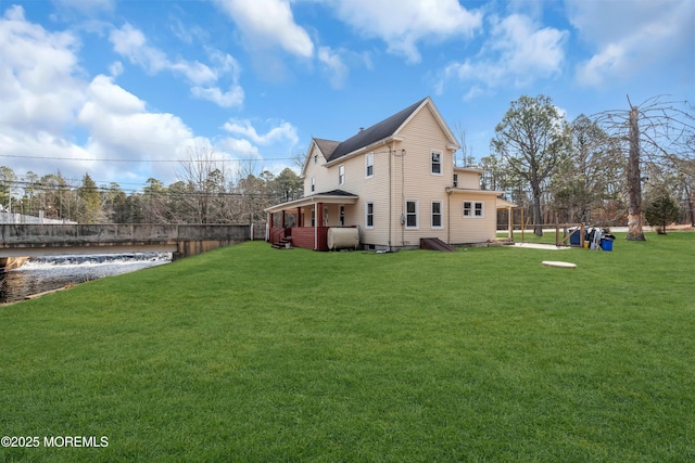 exterior space featuring fence, heating fuel, a yard, and a water view