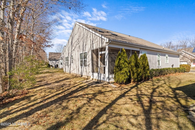 view of home's exterior with a lawn and a sunroom