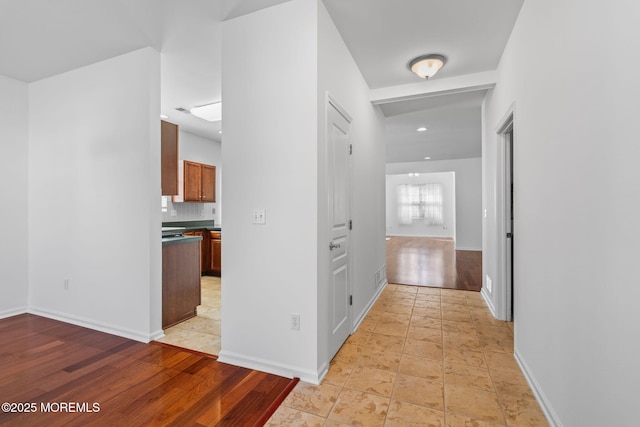 hall with baseboards and light wood-type flooring