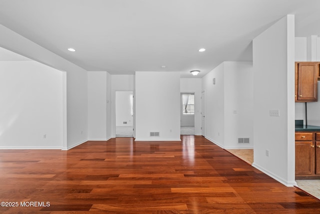 unfurnished living room with visible vents, recessed lighting, baseboards, and wood finished floors