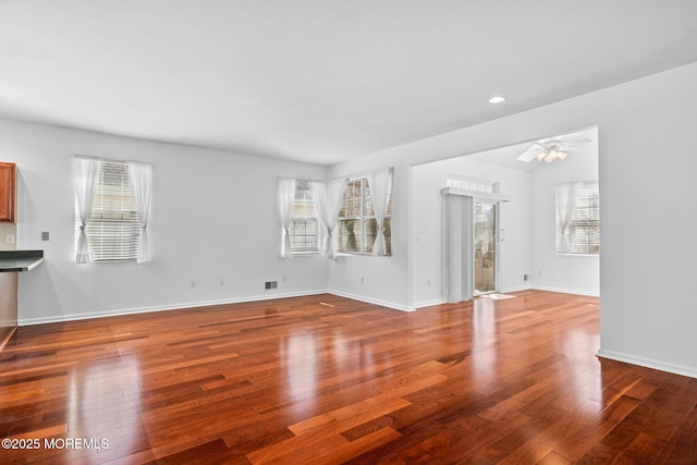 unfurnished living room featuring recessed lighting, ceiling fan, baseboards, and wood-type flooring