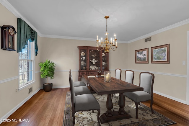 dining room featuring visible vents, wood-type flooring, and ornamental molding