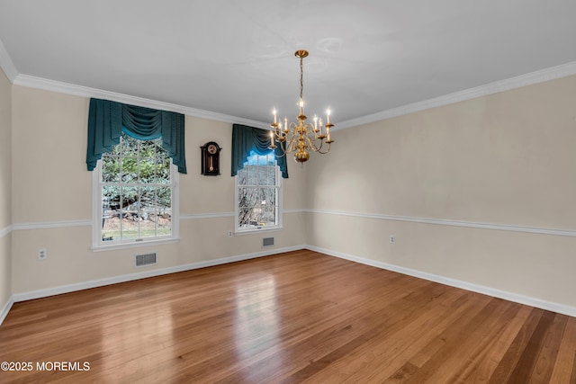 unfurnished dining area with visible vents, wood finished floors, crown molding, and a chandelier