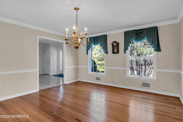 unfurnished dining area featuring visible vents, ornamental molding, and wood finished floors