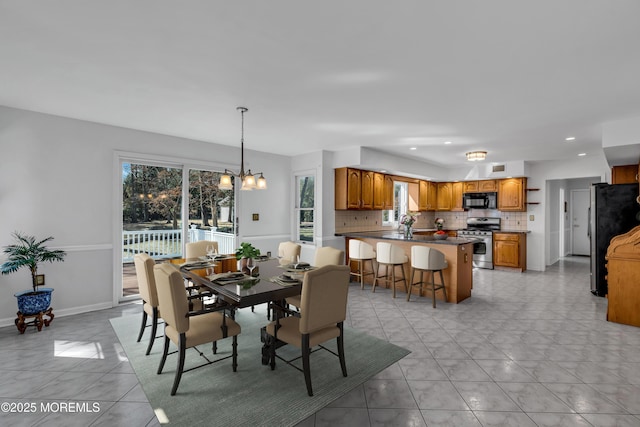 dining area featuring light tile patterned floors, recessed lighting, baseboards, and an inviting chandelier