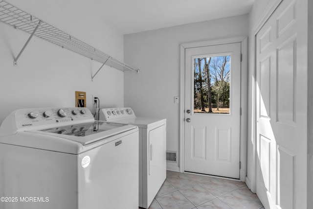 laundry room with laundry area, light tile patterned floors, washing machine and dryer, and visible vents