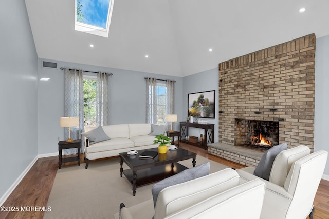 living room with visible vents, baseboards, a fireplace, wood finished floors, and high vaulted ceiling