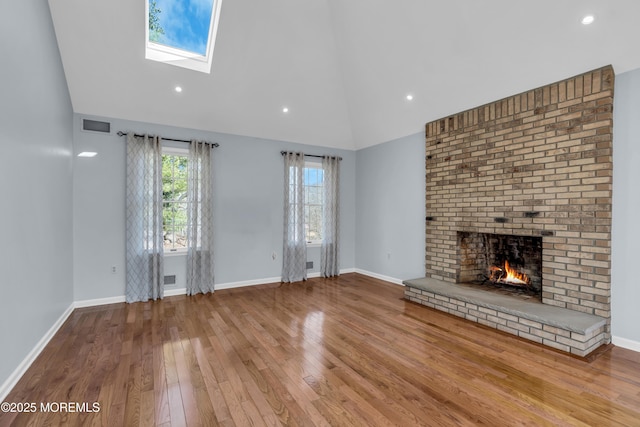 unfurnished living room with a fireplace, visible vents, wood-type flooring, and baseboards