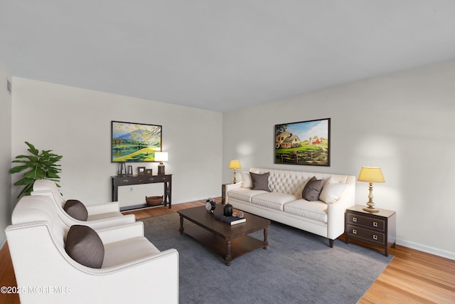 living area with visible vents, baseboards, and wood finished floors