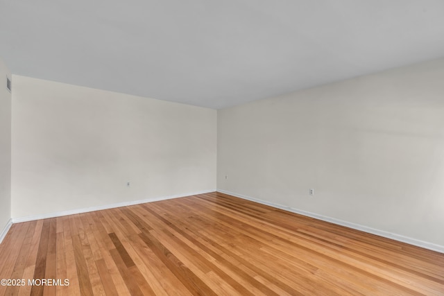 unfurnished room with visible vents, baseboards, and light wood-style flooring