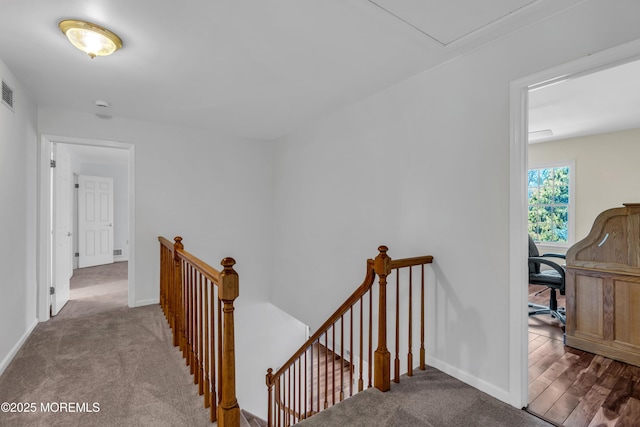 hall featuring carpet flooring, an upstairs landing, and baseboards