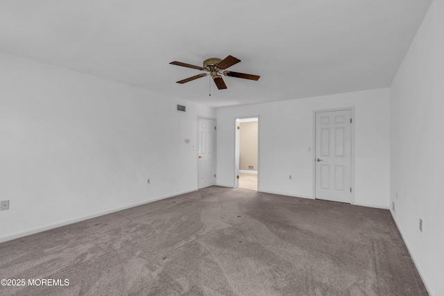 unfurnished room with visible vents, carpet flooring, baseboards, and a ceiling fan