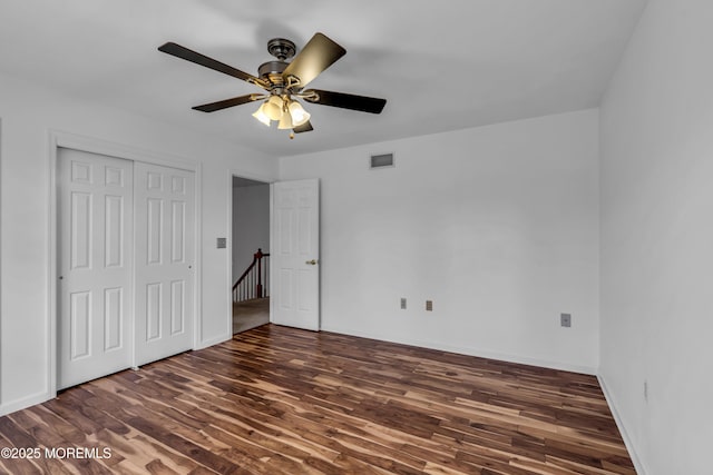 unfurnished bedroom with visible vents, baseboards, wood finished floors, a closet, and a ceiling fan