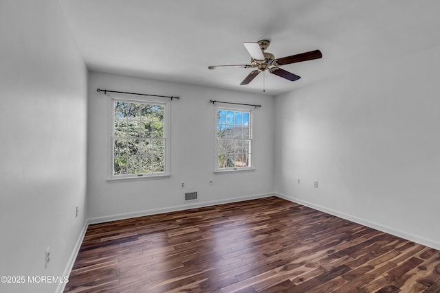 unfurnished room with visible vents, ceiling fan, baseboards, and wood finished floors