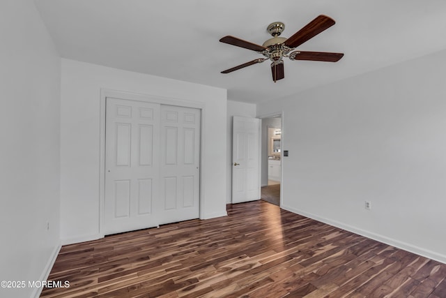 unfurnished bedroom featuring a closet, baseboards, wood finished floors, and a ceiling fan