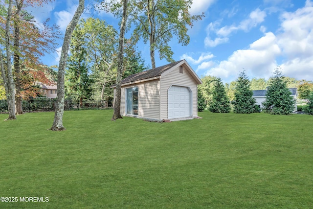 view of yard featuring a garage, an outbuilding, and fence