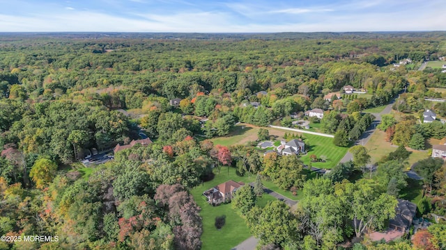 drone / aerial view with a wooded view