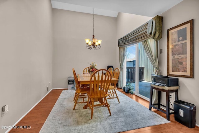 dining area with wood finished floors, baseboards, and a chandelier