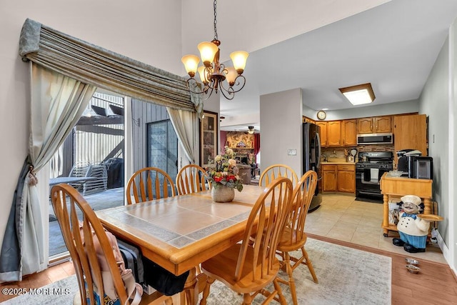 dining area with light wood finished floors and a notable chandelier