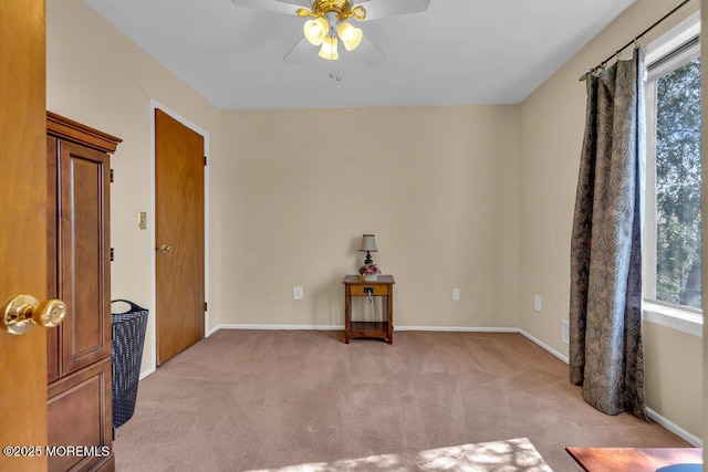 unfurnished room with plenty of natural light, baseboards, and light carpet