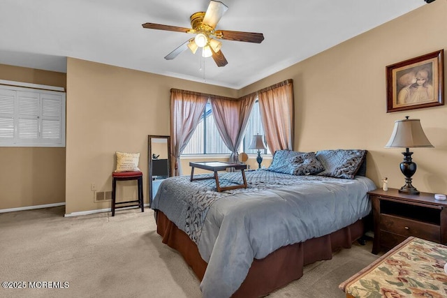 bedroom with ceiling fan, visible vents, baseboards, and light carpet