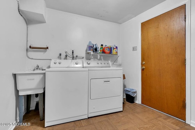 clothes washing area with a sink, laundry area, and washing machine and clothes dryer