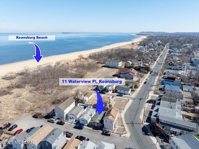 drone / aerial view with a view of the beach, a water view, and a residential view