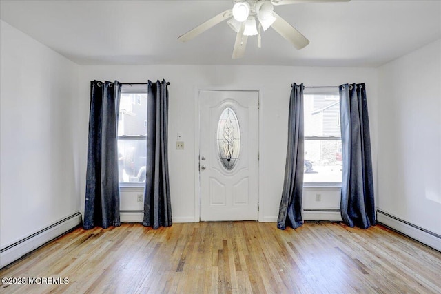 foyer entrance featuring a baseboard radiator and wood finished floors