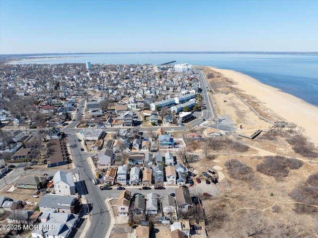 aerial view featuring a view of the beach, a water view, and a residential view