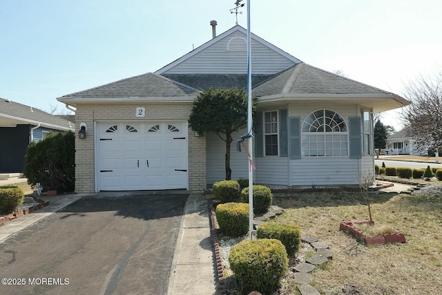 single story home with an attached garage, brick siding, driveway, and roof with shingles