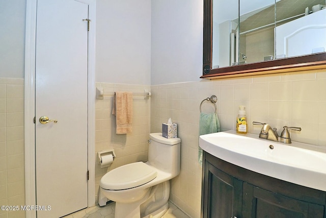 bathroom featuring toilet, tile walls, and vanity