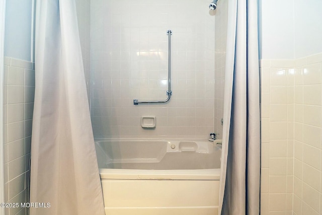 full bath featuring tile walls and shower / tub combo