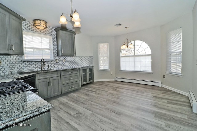 kitchen featuring visible vents, an inviting chandelier, gray cabinetry, a sink, and baseboard heating