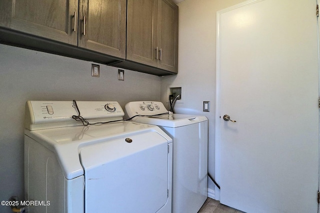 clothes washing area featuring cabinet space and independent washer and dryer