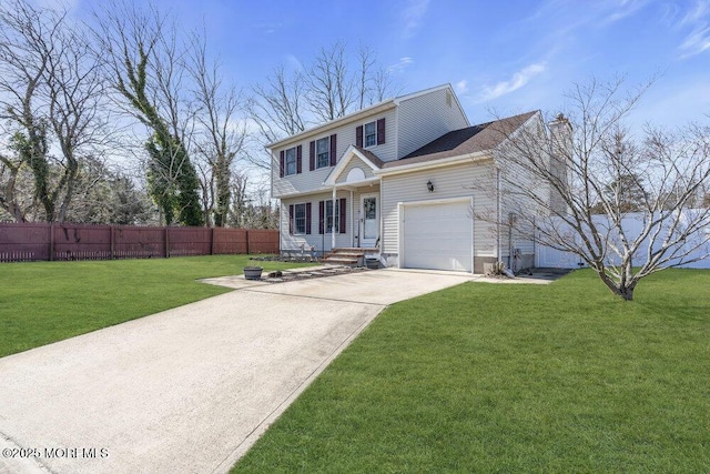 colonial inspired home with driveway, fence, a front yard, an attached garage, and a chimney