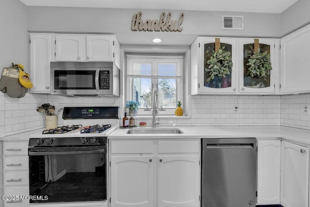 kitchen featuring visible vents, backsplash, appliances with stainless steel finishes, white cabinets, and light countertops