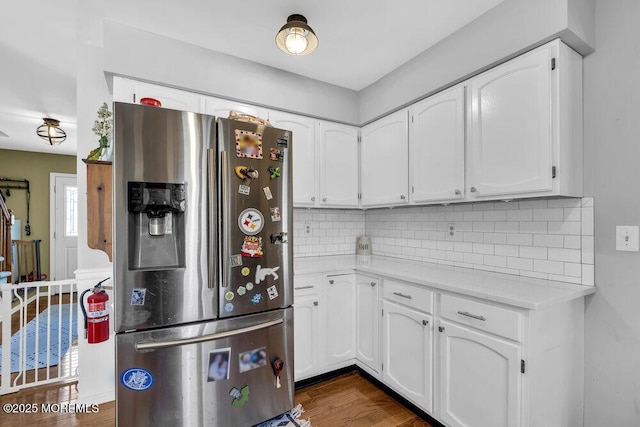 kitchen with decorative backsplash, dark wood-type flooring, white cabinets, and stainless steel fridge with ice dispenser