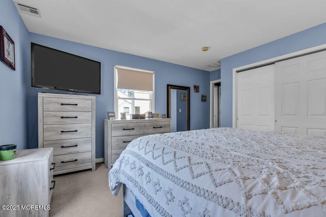 bedroom featuring a closet, visible vents, and light carpet